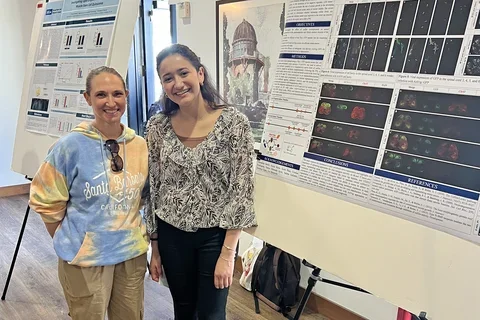two women in front of a poster