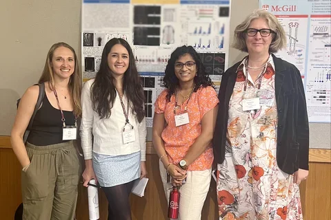 four women standing in front of a scientific poster