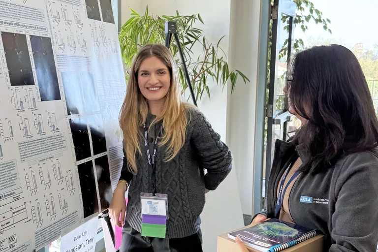 Smiling woman presenting a scientific poster at a meeting