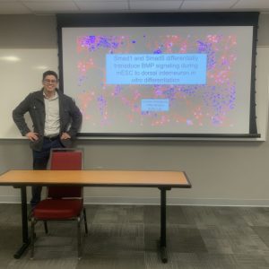 Man standing in front of his research presentation.